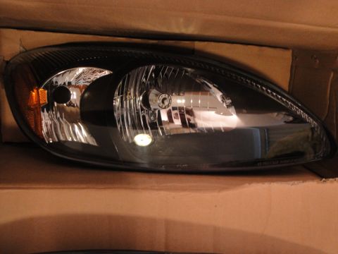 2003 Ford Taurus - Headlight assembly for a car, shown in its packaging.