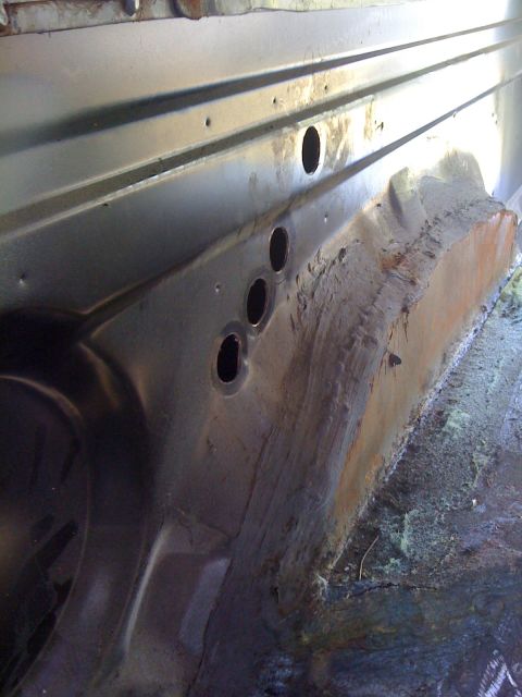 1992 Ford C-350 (Centurion Conversions) - Close-up of the interior wheel well area, showing metal construction and some rust.