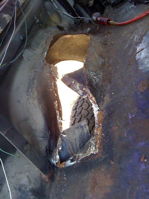 1992 Ford C-350 (Centurion Conversions) - Rusted wheel well area with a tire visible through the opening.