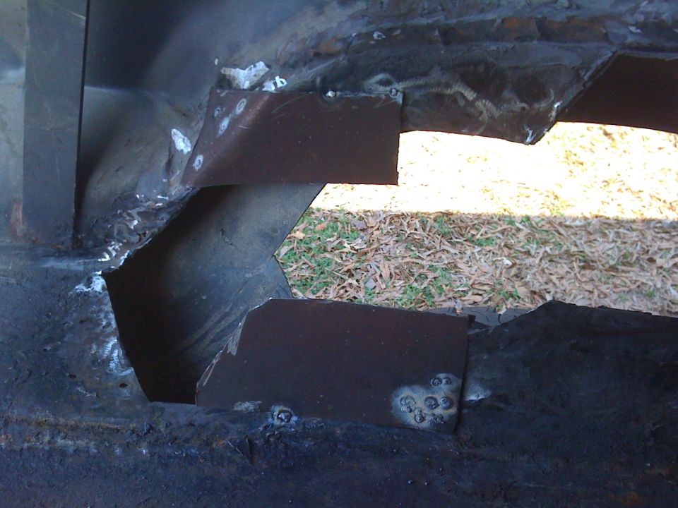 welded metal patches on vehicle frame, looks like rust repair