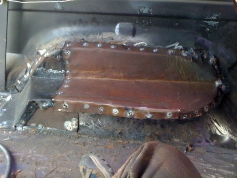 1992 Ford C-350 (Centurion Conversions) - Close-up of a rusted metal patch welded onto the interior floor of a vehicle.