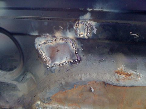 1992 Ford C-350 (Centurion Conversions) - Welded patches on a vehicle's interior floor pan show signs of rust and repair work.