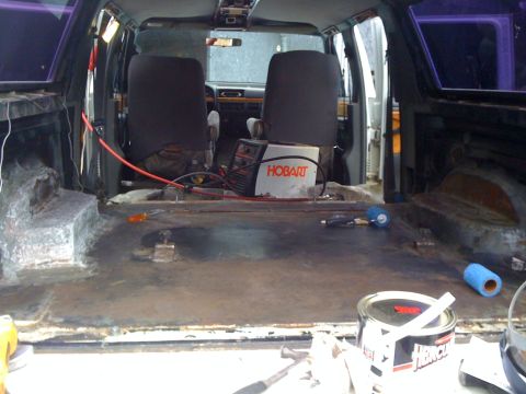 1992 Ford C-350 (Centurion Conversions) - Van interior undergoing work, with a welder and various tools present on the floor.