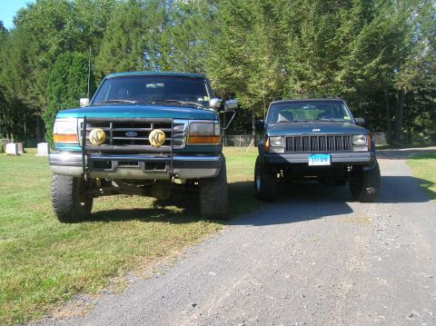 1995 Jeep Cherokee - A 1995 Jeep Cherokee and a Ford Bronco are parked side-by-side on a gravel road.