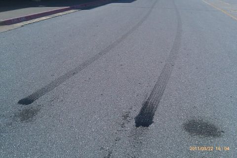 2000 Mercury Grand Marquis - Tire marks and fluid stains are visible on the asphalt, indicating recent vehicle activity.