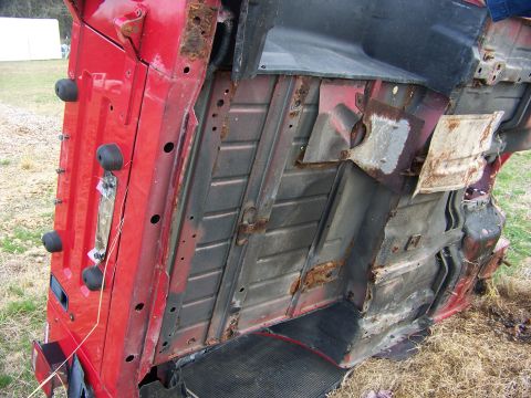 1992 Jeep YJ - The underside of a red vehicle is shown, with visible rust and damage. A website logo is in the corner.