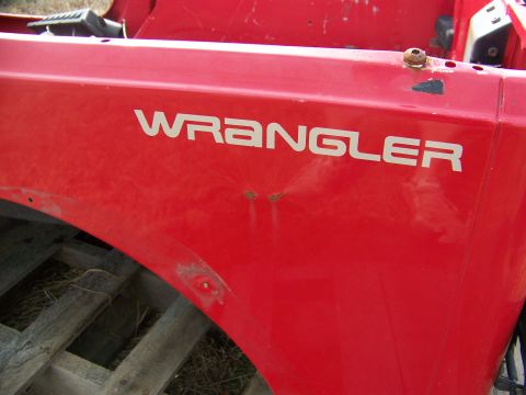 1992 Jeep YJ - Close-up of a red Jeep Wrangler fender showing the side lettering.