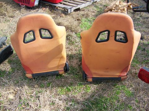 1992 Jeep YJ - Pair of aftermarket racing seats shown outdoors on dry grass.