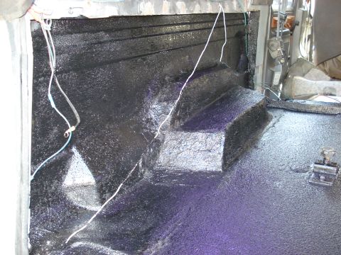 1992 Ford C-350 (Centurion Conversions) - The interior floor of a vehicle has been coated with a protective black spray-on liner material.