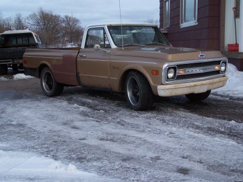 1969 Chevrolet C/K Pickup - A classic Chevrolet pickup truck is parked outside a house on a cold, snowy day.