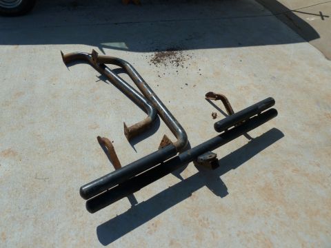 1992 Ford Mustang - Two black metal bumper guards, one with a double bar design, lie on a concrete surface.
