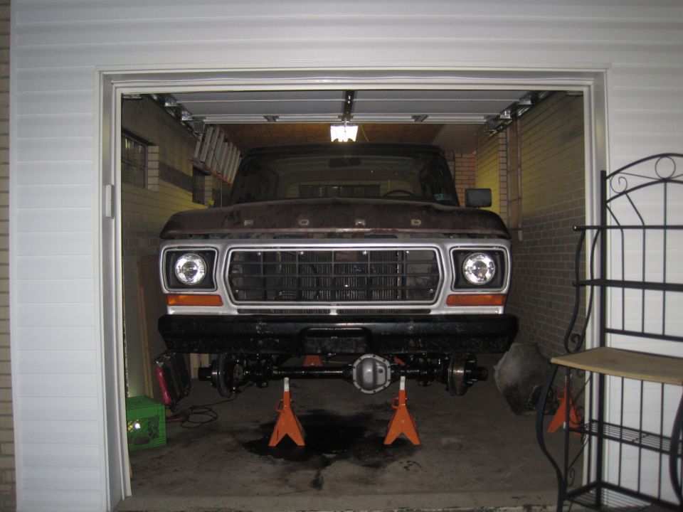 1979 Ford Bronco front end in garage, raised on jack stands for suspension work