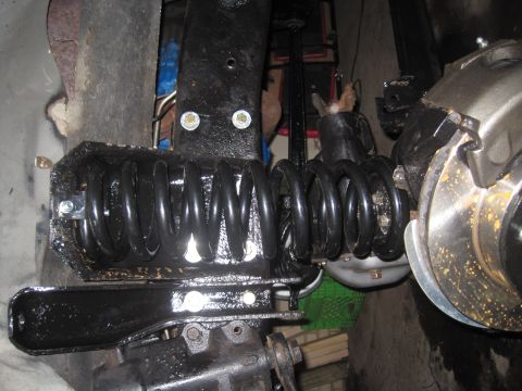 1979 Ford Bronco - Close-up of the front suspension system, likely from a 1978 Ford Bronco, showing coil springs and brake components.