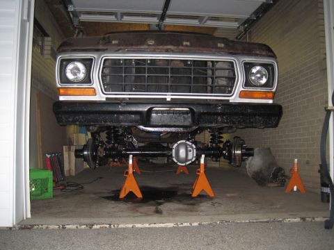 1979 Ford Bronco - Front suspension and drivetrain of a 1978 Ford Bronco undergoing work in a garage.