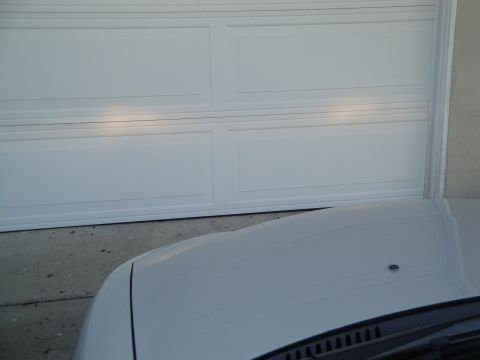 2003 Ford Taurus - Headlights of a car are illuminated in front of a closed garage door.