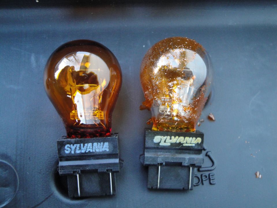 Two Sylvania amber light bulbs, one appears new, the other shows signs of damage and melting