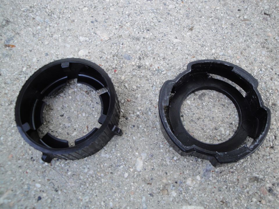 Two black plastic headlight retaining rings on concrete