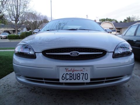 2003 Ford Taurus - A silver 2003 Ford Taurus is parked in a driveway, facing the camera.