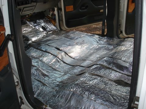 1992 Ford C-350 (Centurion Conversions) - Wide interior view through both open doors of a white extended-cab truck, showing the entire floor pan laid with overlapping sheets of foil…