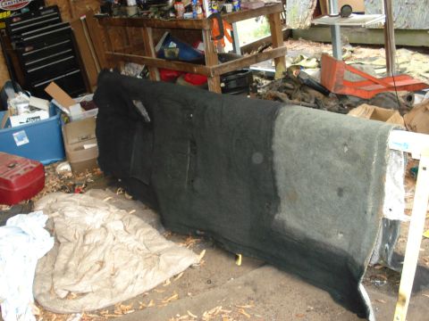 1992 Ford C-350 (Centurion Conversions) - An interior panel, possibly from a vehicle, is seen leaning against a workbench in a garage setting.