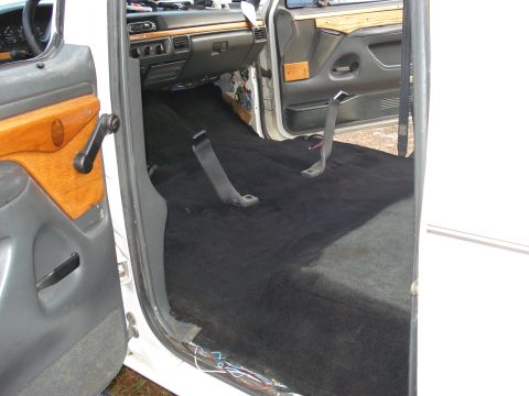 1992 Ford C-350 (Centurion Conversions) - The interior of a van is shown with the carpet removed, exposing the floor and seatbelt mounting points.