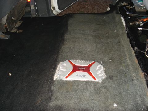 1992 Ford C-350 (Centurion Conversions) - An aftermarket audio amplifier is installed in the floor of a vehicle's interior.