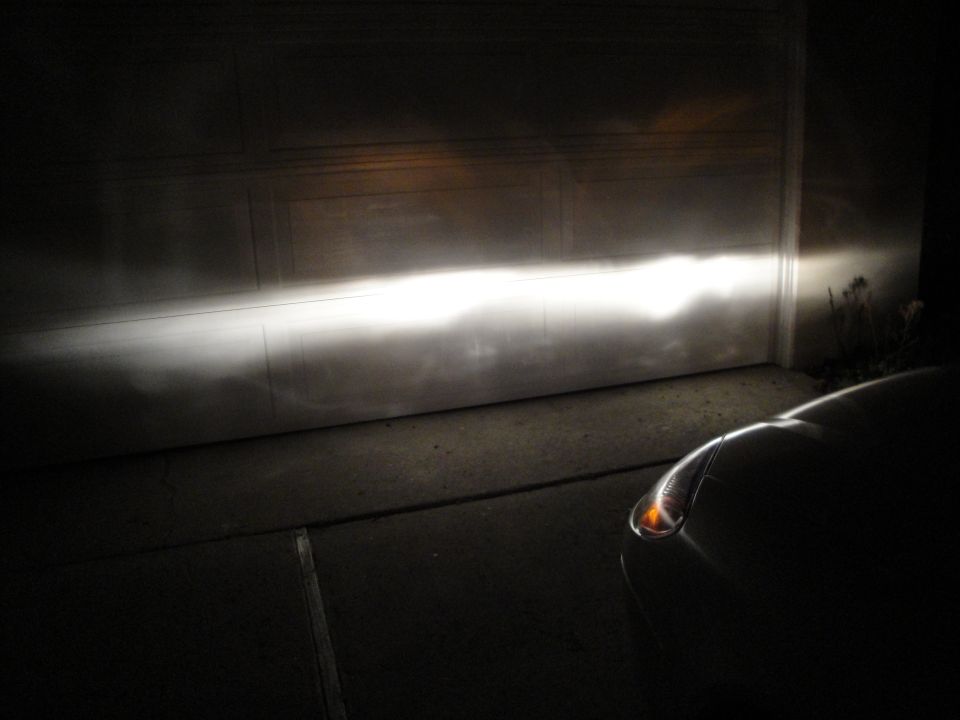 Night headlight beam pattern with sharp cutoff line projected on a garage door