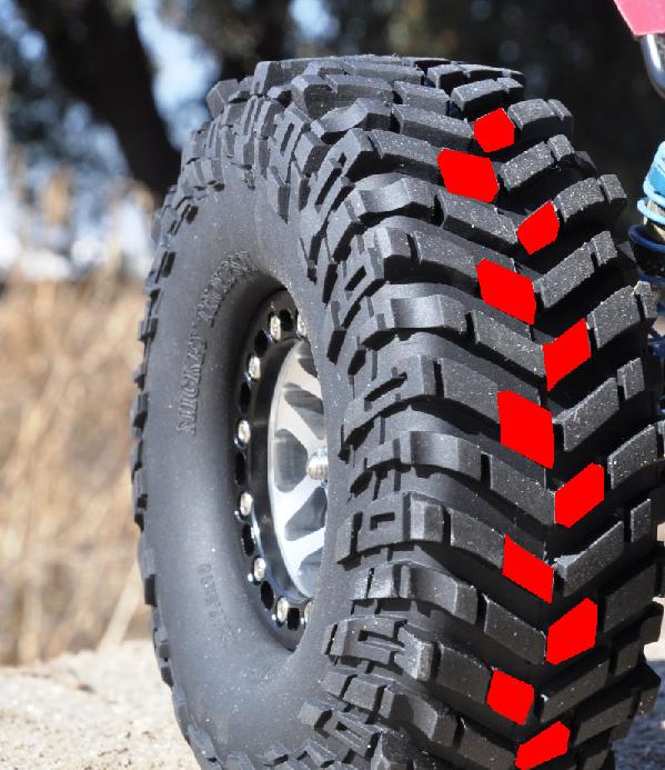 Mud-terrain tire on polished beadlock wheel with red marks over shoulder lugs