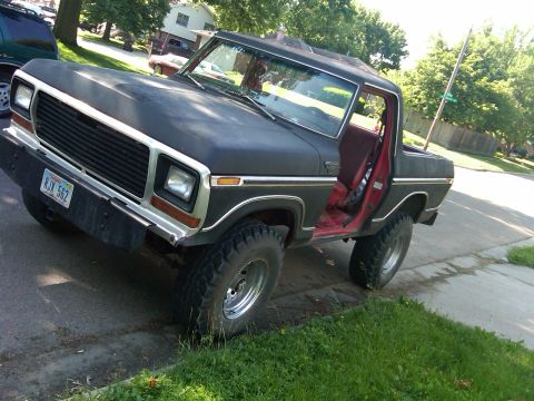 1978 Ford Bronco - This 1978 Ford Bronco features a black exterior, a red interior, and a lifted suspension, giving it a appearance.