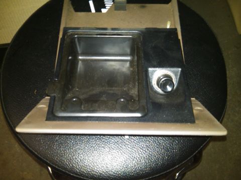 1993 Ford Bronco - Close-up of a vehicle's interior ashtray and cigarette lighter assembly.
