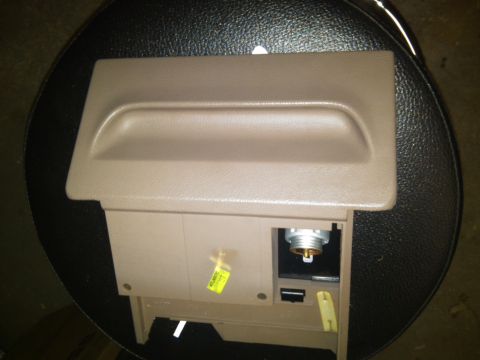 1993 Ford Bronco - This is a close-up of a vehicle's interior ashtray and lighter assembly, showing its tan plastic construction and components.