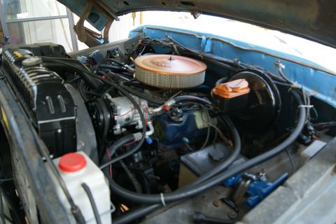 1978 Ford Bronco - Engine bay of a blue 1978 Ford Bronco, showing the V8 engine and associated components.