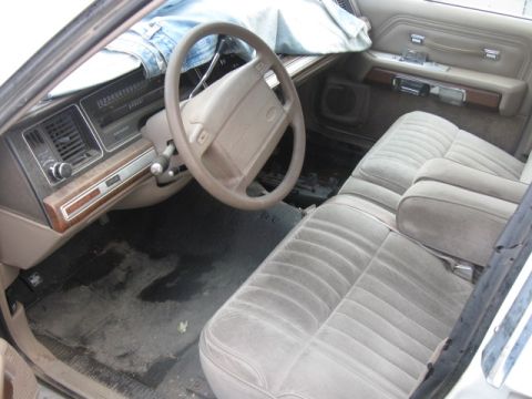 1991 Ford Crown Victoria LTD - The interior of a 1991 Ford Crown Victoria LTD, a tan dashboard, steering wheel, and plush seats.