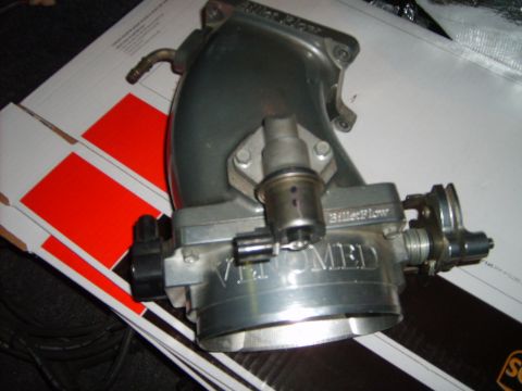 1993 Ford Crown Victoria - Close-up of a silver throttle body assembly with visible branding, likely an aftermarket performance part.