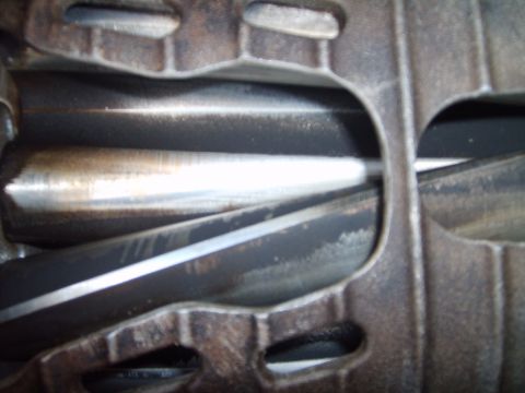 1993 Ford Crown Victoria - Extreme close-up looking down into the rotor cavity of a Roots-type supercharger case, showing the polished twisted lobes of the rotor pack…