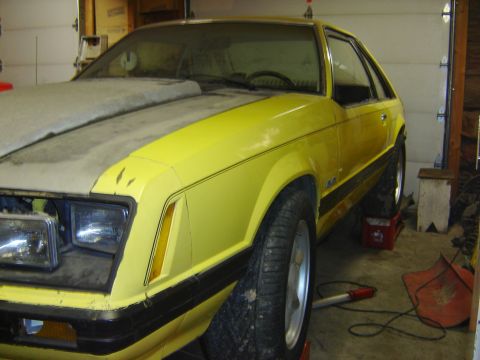 1979 Ford Mustang - Yellow 1979 Ford Mustang in a garage, showing its front 3/4 view.