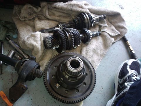 1995 Ford Probe - Car transmission gears and differential assembly laid out on a towel with tools nearby.