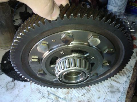 1995 Ford Probe - A hand holds a large gear with a bearing assembly, likely a vehicle differential part.