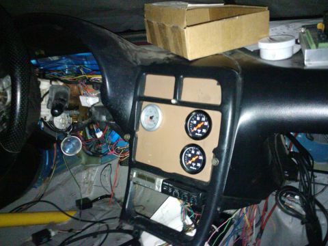 1995 Ford Probe - The dashboard of a car is visible, with many wires exposed and several aftermarket gauges installed.