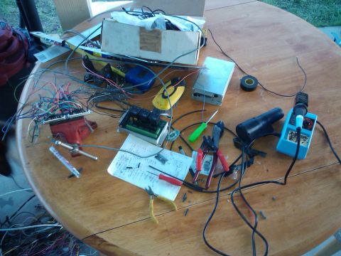 1995 Ford Probe - A cluttered workbench displays various electronic components and tools, suggesting a project in progress.