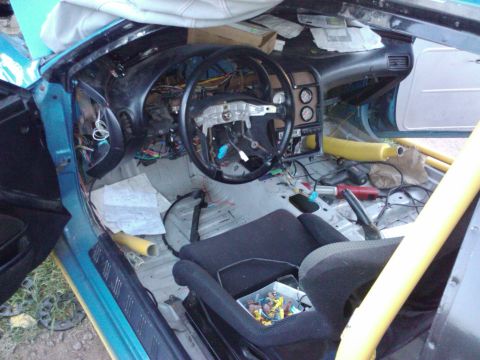 1995 Ford Probe - The interior of a car is shown with the dashboard disassembled and wiring exposed.
