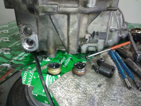 1995 Ford Probe - Close-up of a disassembled automotive transmission component with various tools laid out.