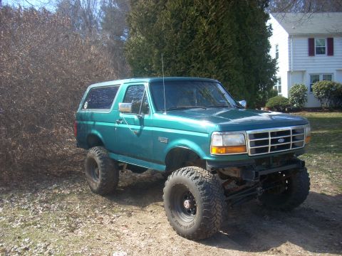 1996 Ford Bronco - This lifted 1996 Ford Bronco features a vibrant teal paint job and aggressive off-road tires.