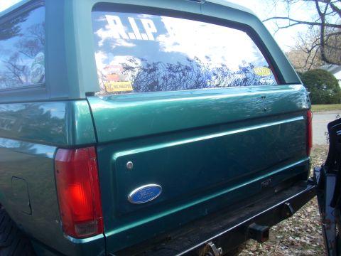 1996 Ford Bronco - The rear of a green Ford Bronco is shown, a "R.I.P." decal on the window.