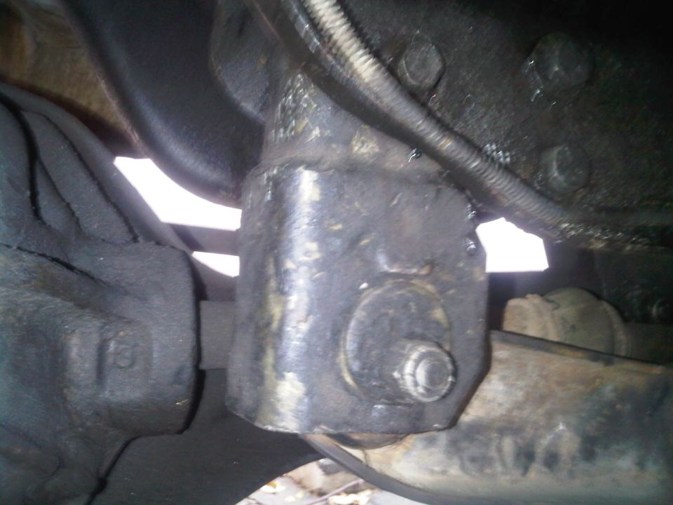 Close-up of a greasy suspension component with a bolt