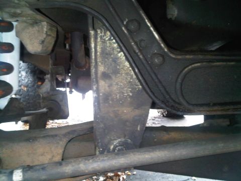 1986 Ford Bronco - Close-up view of the underside of a vehicle, focusing on suspension and frame components.