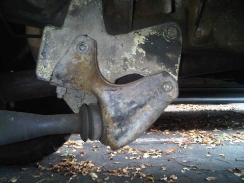 1986 Ford Bronco - A close-up view of a worn suspension component, likely from a truck or SUV, showing rust and a rubber bushing.