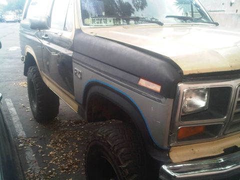1986 Ford Bronco - Front quarter panel and fender of a Ford Bronco, showing some body damage and modifications.