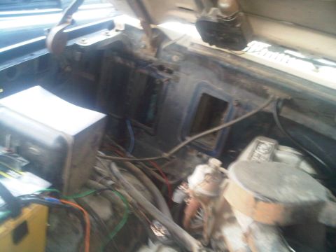 1986 Ford Bronco - The engine bay of a 1986 Ford Bronco shows exposed wiring and components.
