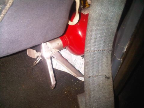1986 Ford Bronco - Fire extinguisher secured to car seat. Some text visible on paper underneath.